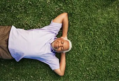 man laying on green grass