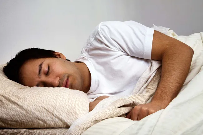 photo of man asleep in bed