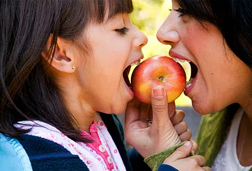 Mother and daughter sharing apple