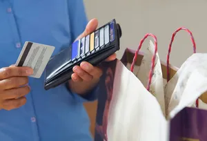 Close-up of hands pulling credit card from wallet