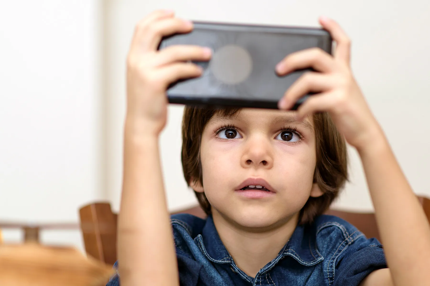 photo of child playing with handheld video game