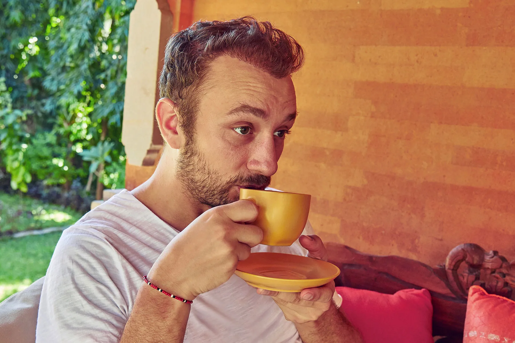 photo of man drinking coffee on porch