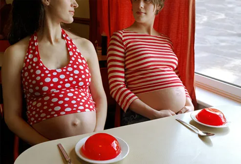 Two pregnant women eating jello in cafe