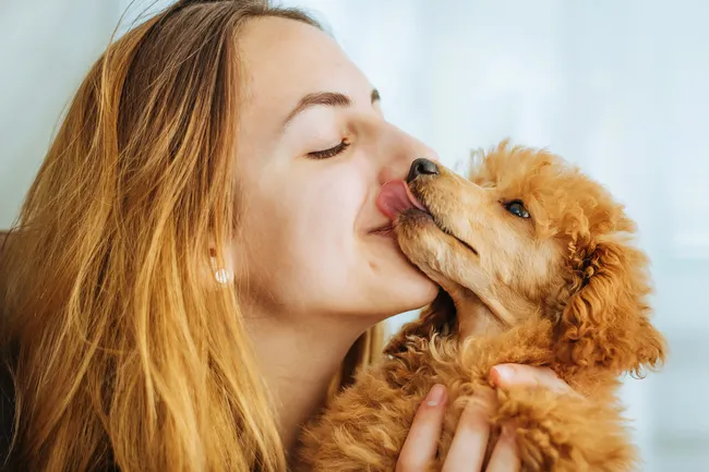 woman kisses dog