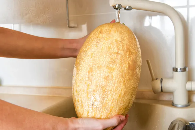 photo of woman washing melon