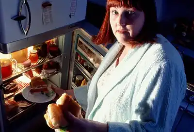woman raiding refrigerator at night