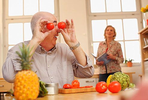 Mature man holding tomatoes up to eyes