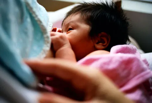 Asian newborn baby breastfeeding