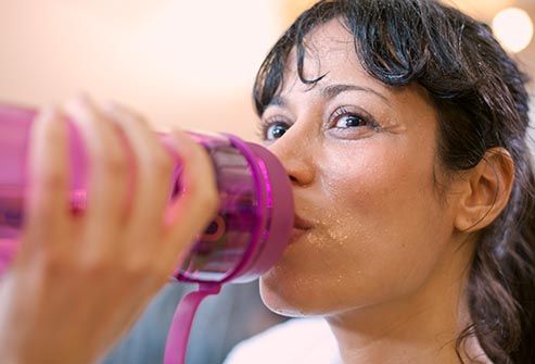 woman drinking water in gym