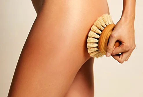 woman exfoliating hip with brush