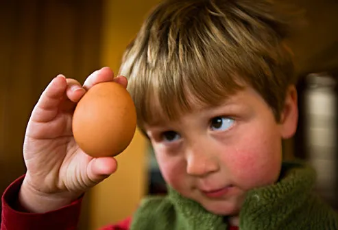Young boy contemplating an egg