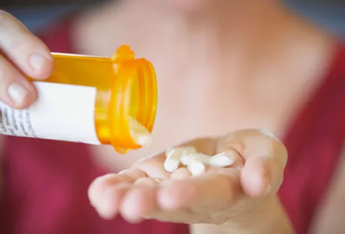 Woman Pouring Pills Into Hand