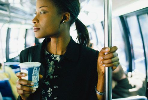 Businesswoman on bus holding cup of coffee