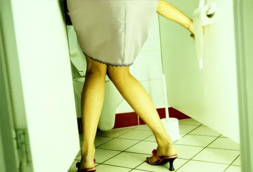Woman entering bathroom stall, knees together