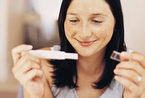 Smiling Woman Reading Pregnancy Test