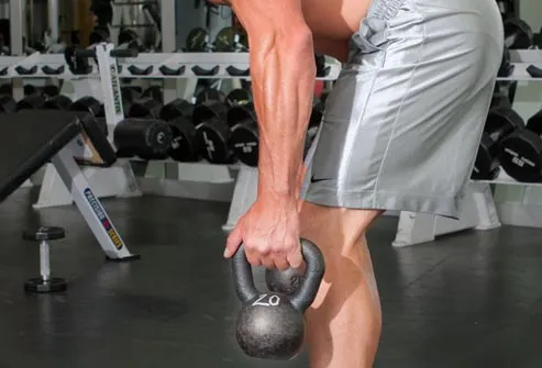 man working out with kettlebells 