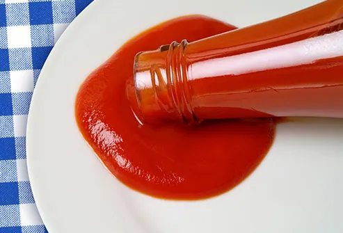 pouring ketchup onto plate