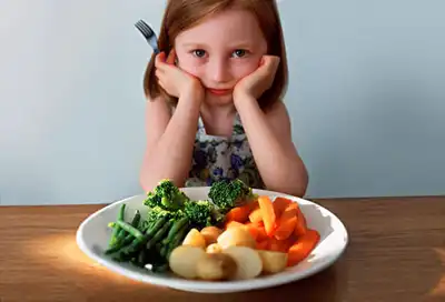 Girl in front of plate of veggies