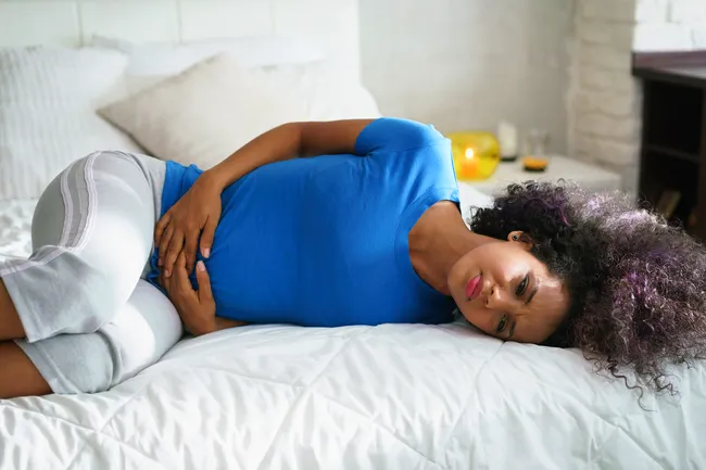 photo of woman in bed with period cramps
