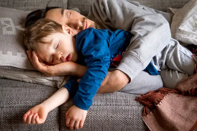 dad and son napping on couch