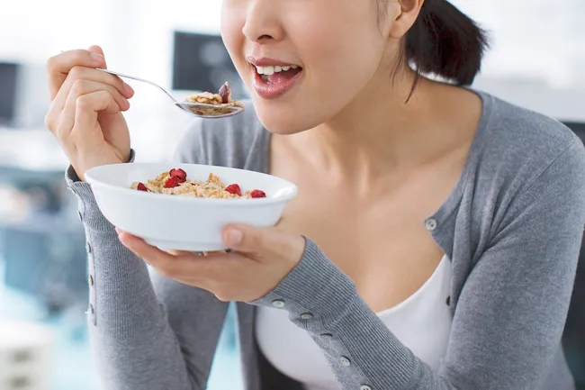 photo of woman eating cereal