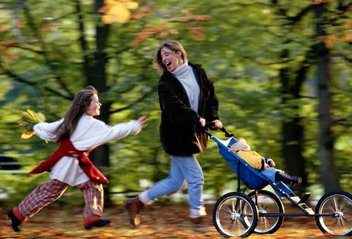 Woman and children running down forest path
