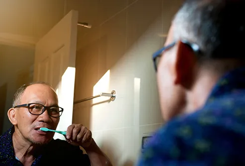 mature man brushing teeth