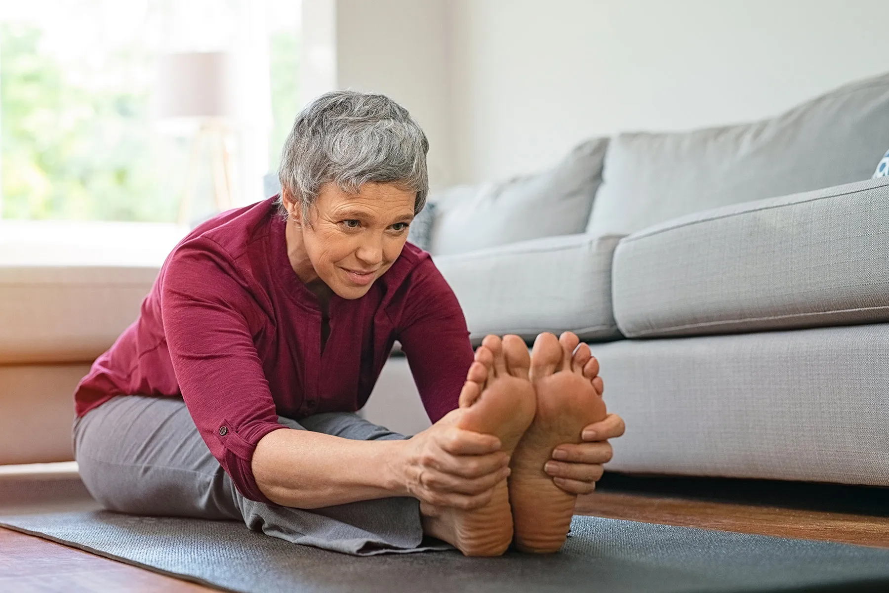 photo of mature woman stretching on exercise mat