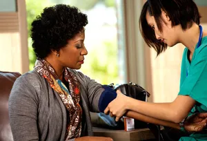 nurse measuring womans blood pressure