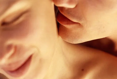 Man kissing woman's neck