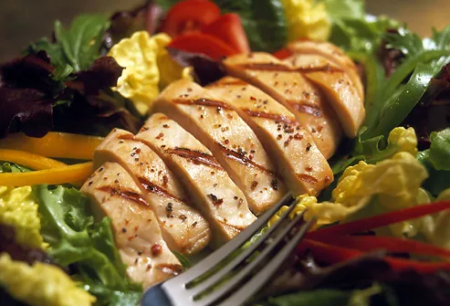 Sliced chicken breast on salad