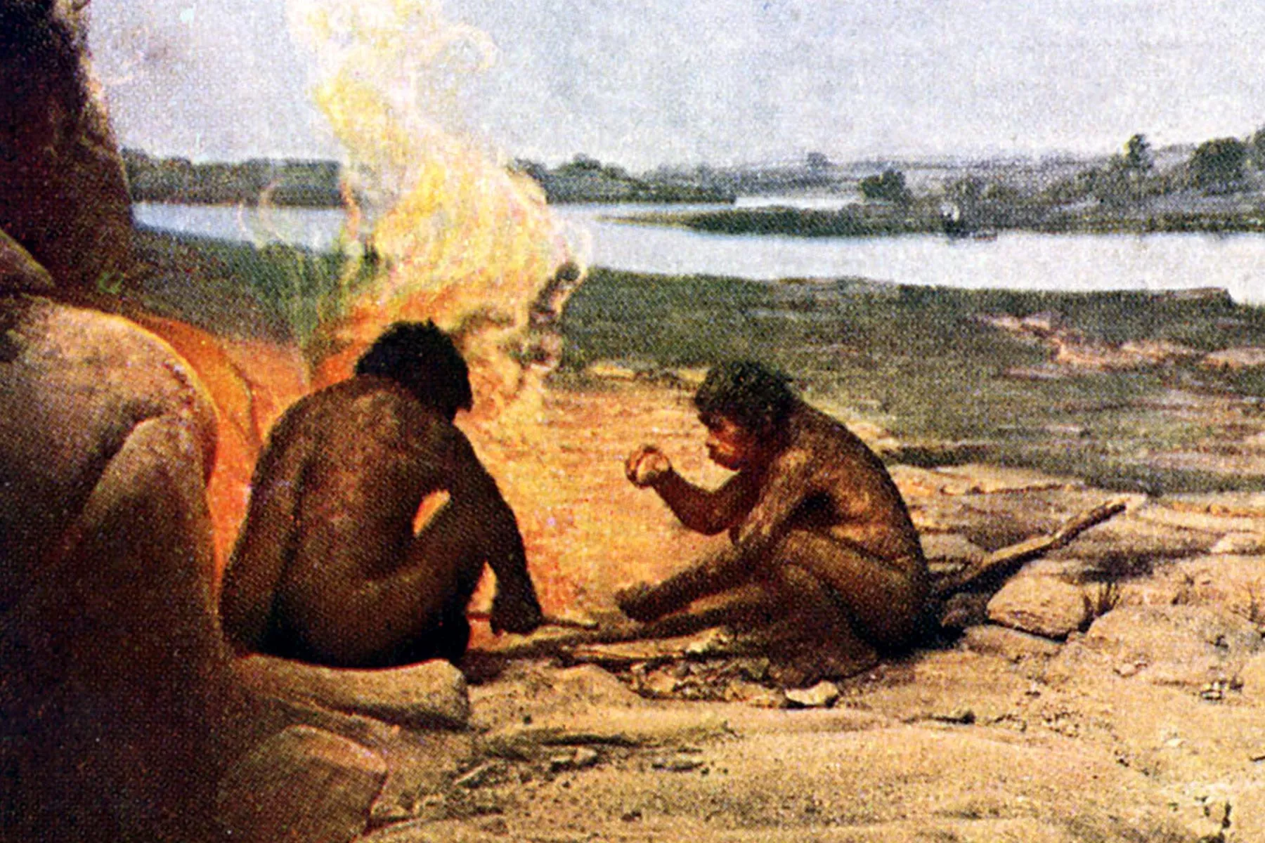 photo of prehistoric man by fire