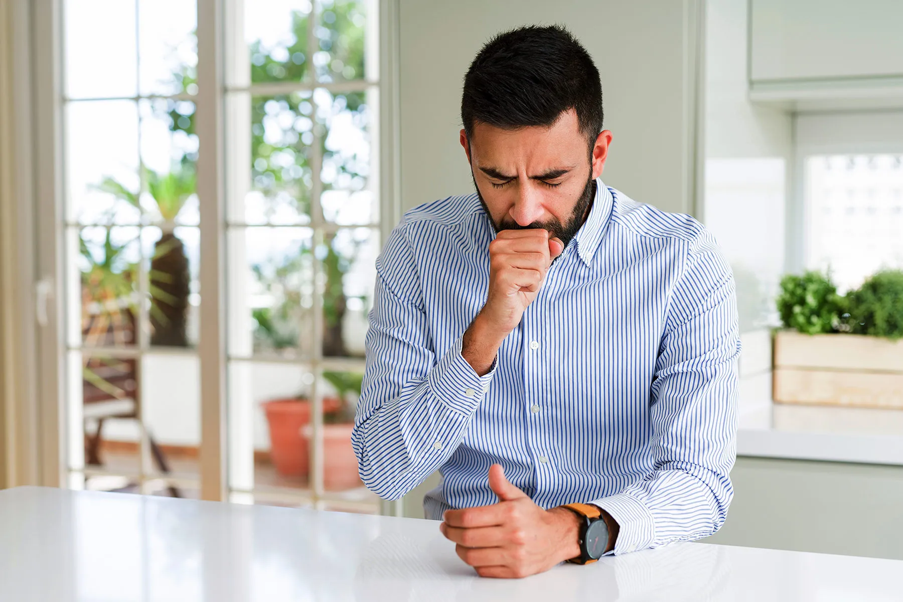 photo of man coughing at home