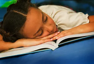 girl asleep on book