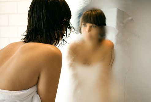 Woman Looking at Reflection in Steamy Mirror