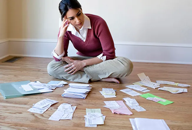woman on floor reviewing bills