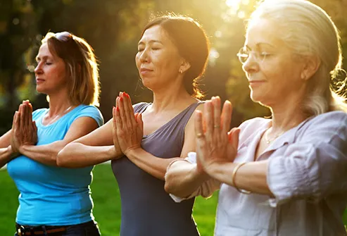mature women practicing yoga outdoors