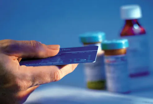 Credit card in hand with prescription bottles