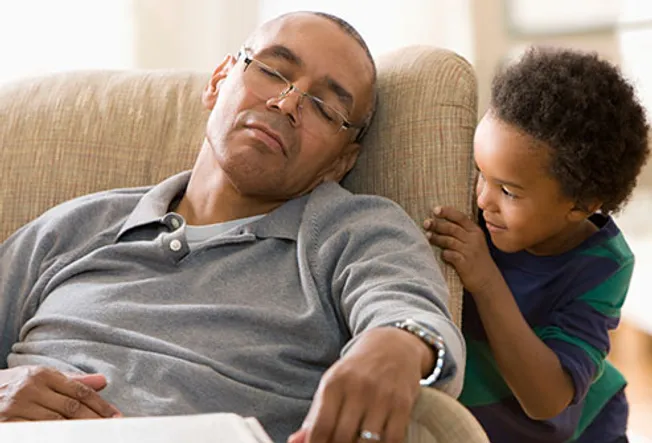Grandson watching grandfather sleeping