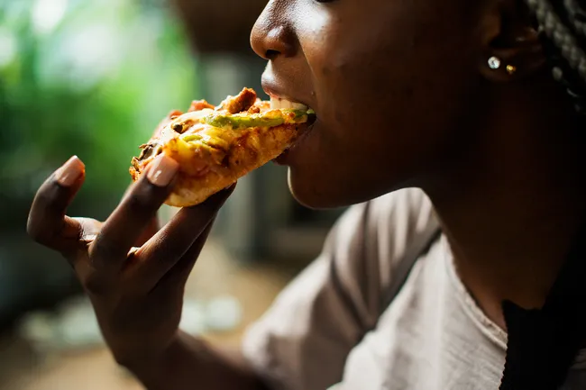 photo of person eating pizza