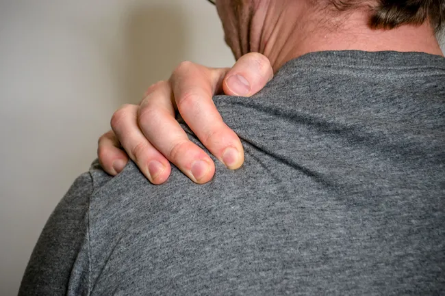 photo of person gripping shoulder