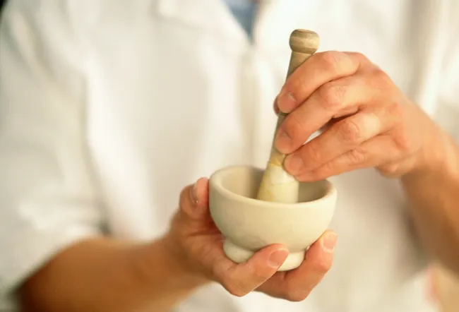 Pharmacist mixing medicine with mortar and pestle