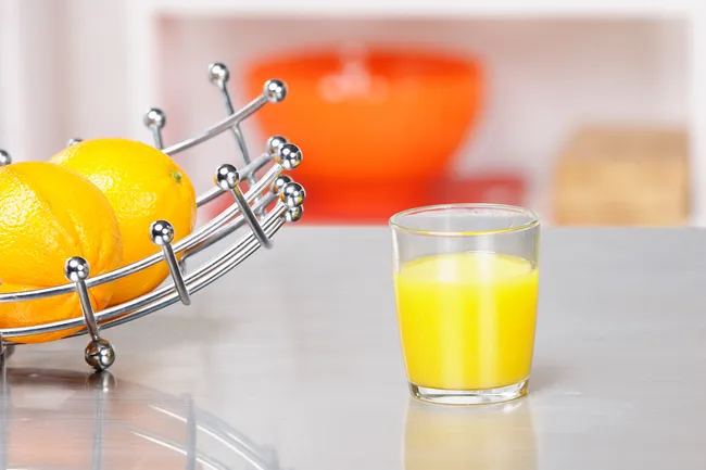 photo of glass of orange juice on countertop