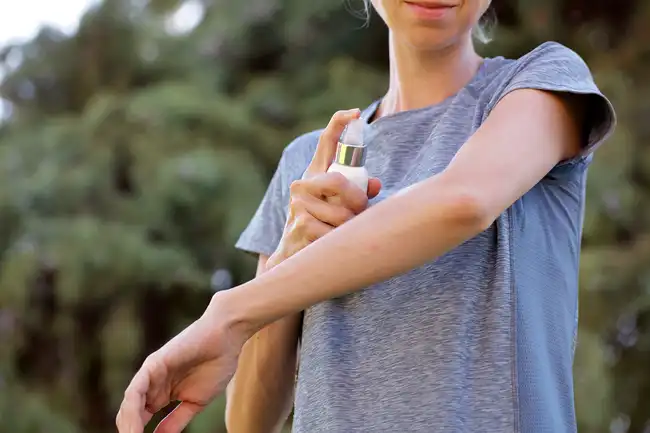 woman applying repellent