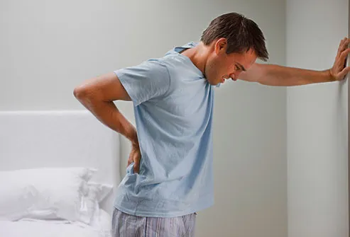 Young man cringing from lower back pain
