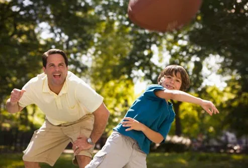 father and son playing football