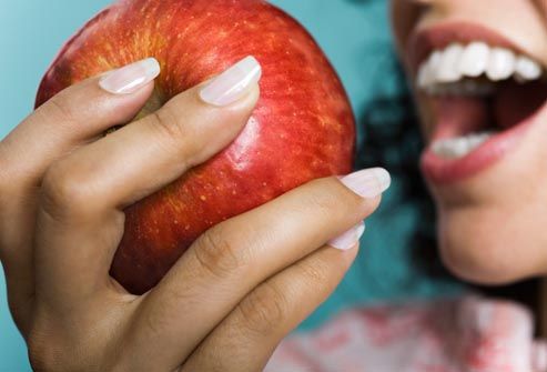 woman biting into apple