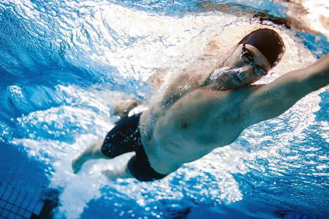 photo of man swimming laps in pool