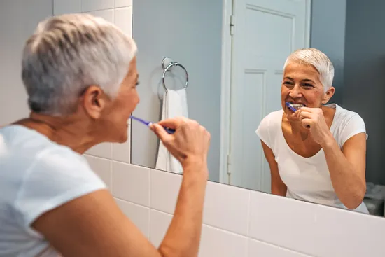 photo of woman brushing her teeth