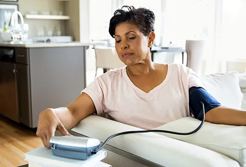 mature woman checking blood pressure at home